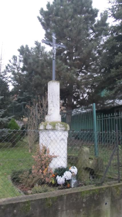 Obelisk z metalowym krzyżem i stary, kamienny krzyż leżący obok.jpg